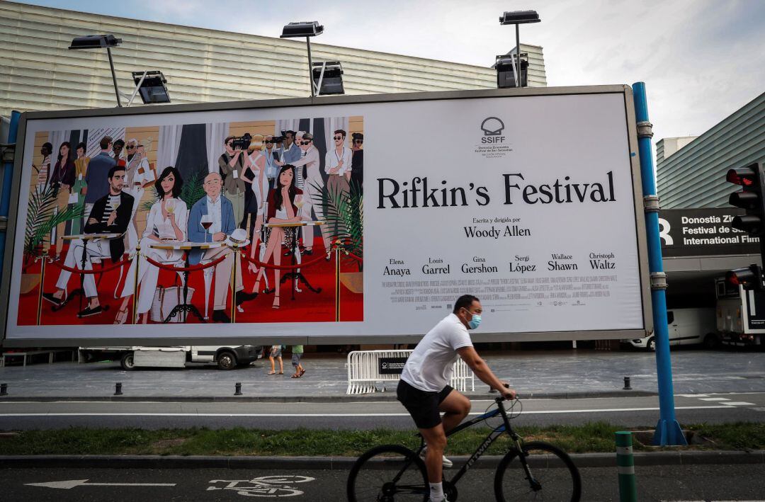 Un ciclista pasa junto al cartel de la última película de Woody Allen