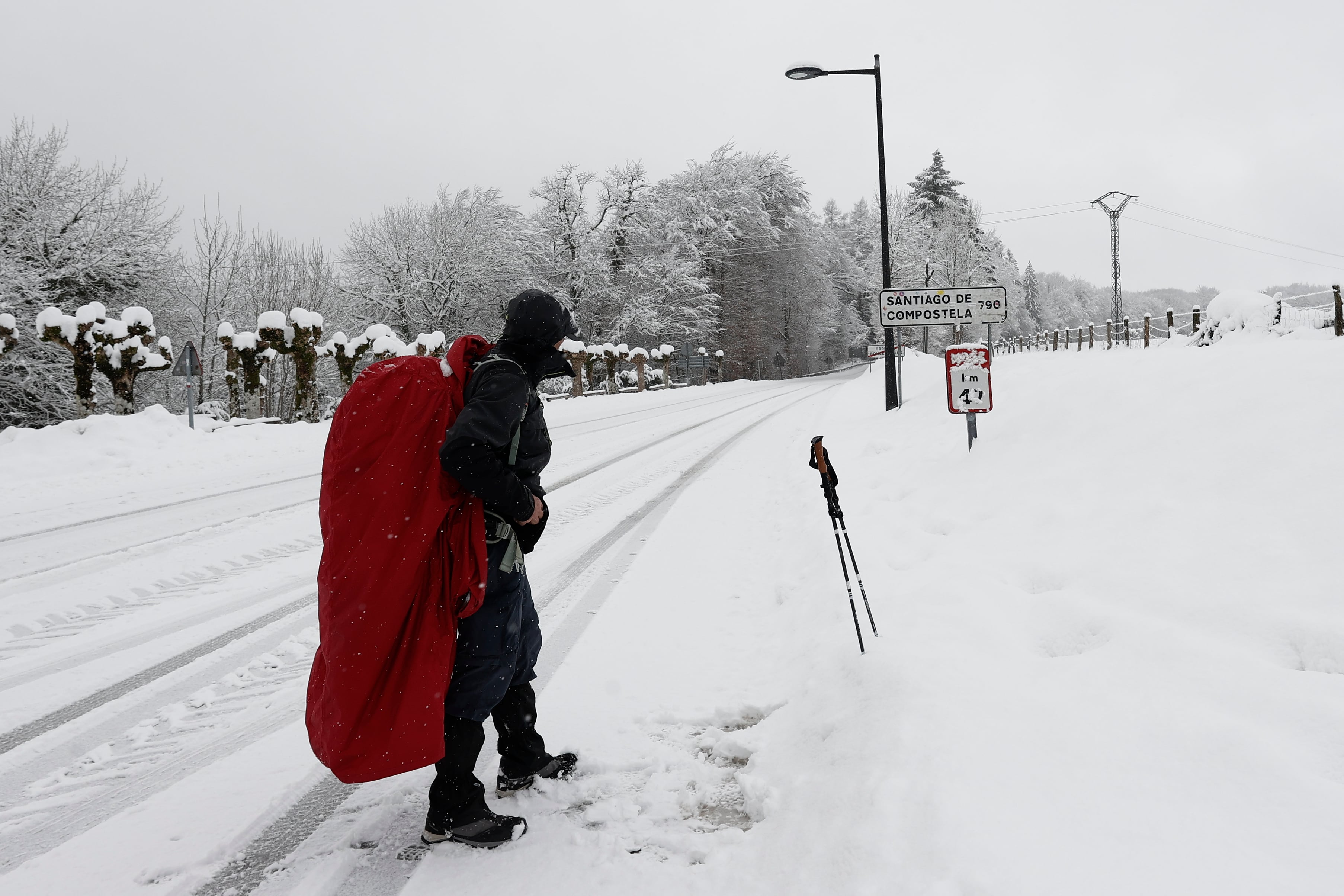 RONCESVALLES, 10/01/2024.- Un peregrino realiza su camino por la carretera ante la imposibilidad de hacerlo por el camino original por la presencia de nieve en una jornada donde la normalidad es la nota dominante en las carreteras navarras a primeras horas de este miércoles en el que la Comunidad Foral está en alerta por nevadas. Así, tan solo son necesarias las cadenas para circular por la NA-137 Burgui-Isaba-Francia, puerto de Belagua, desde el kilómetro 51, desde el refugio. EFE/ Jesús Diges
