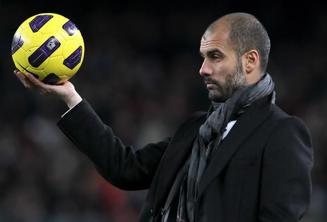 El entrenador del F.C. Barcelona, Pep Guardiola, sujeta el balón durante el partido correspondiente vigésima jornada del Campeonato Nacional de Liga de Primera División ante el Racing