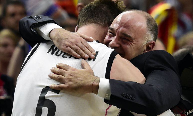 Real Madrid's coach Pablo Laso (R) celebrates with Real Madrid's Italian forward Andres Nocioni after winning the Euroleague Final Four basketball match final between Real Madrid and Olympiacos Pireus at the Palacio de los Deportes in Madrid on May 17, 20