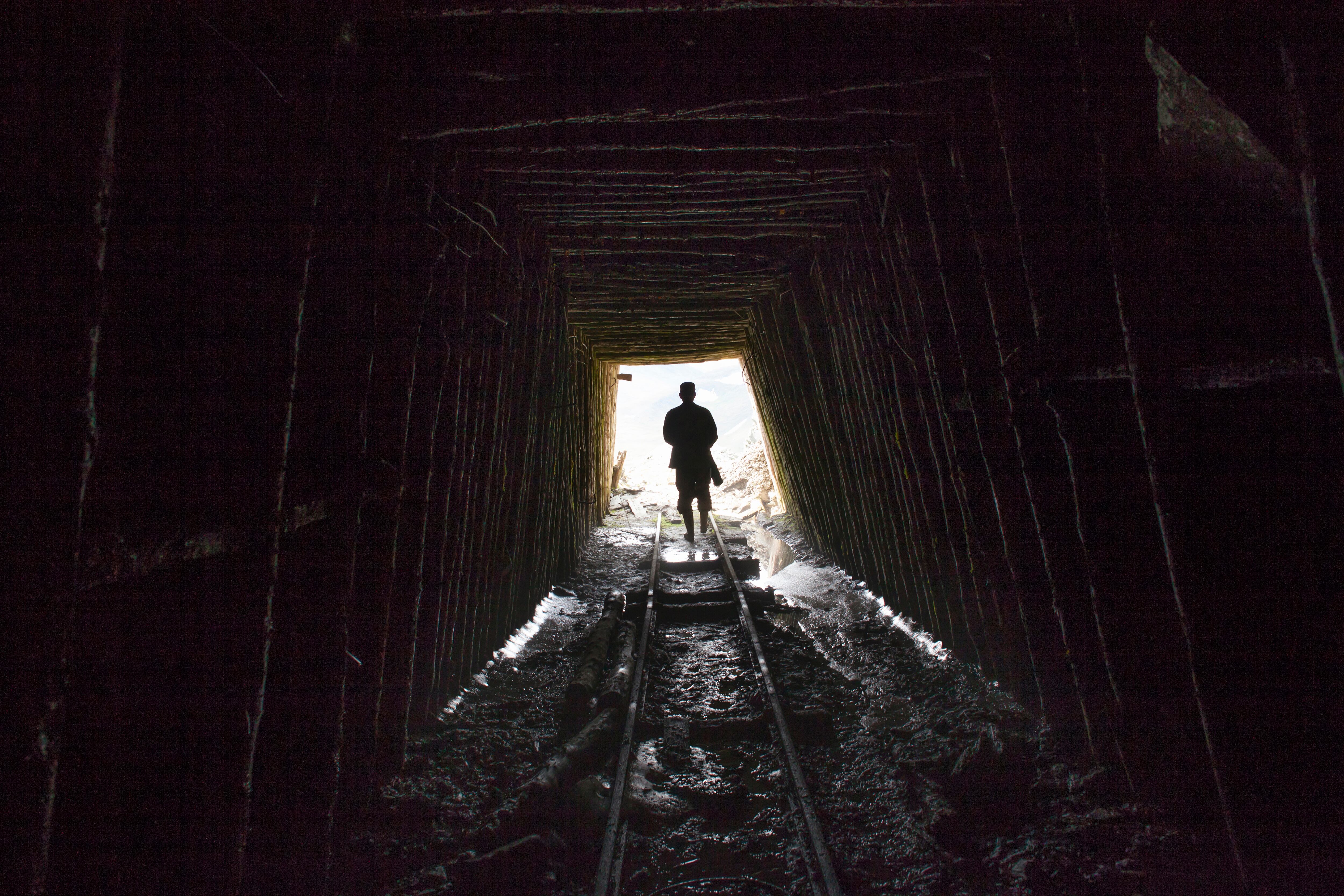 Mari man walking on tracks in mine