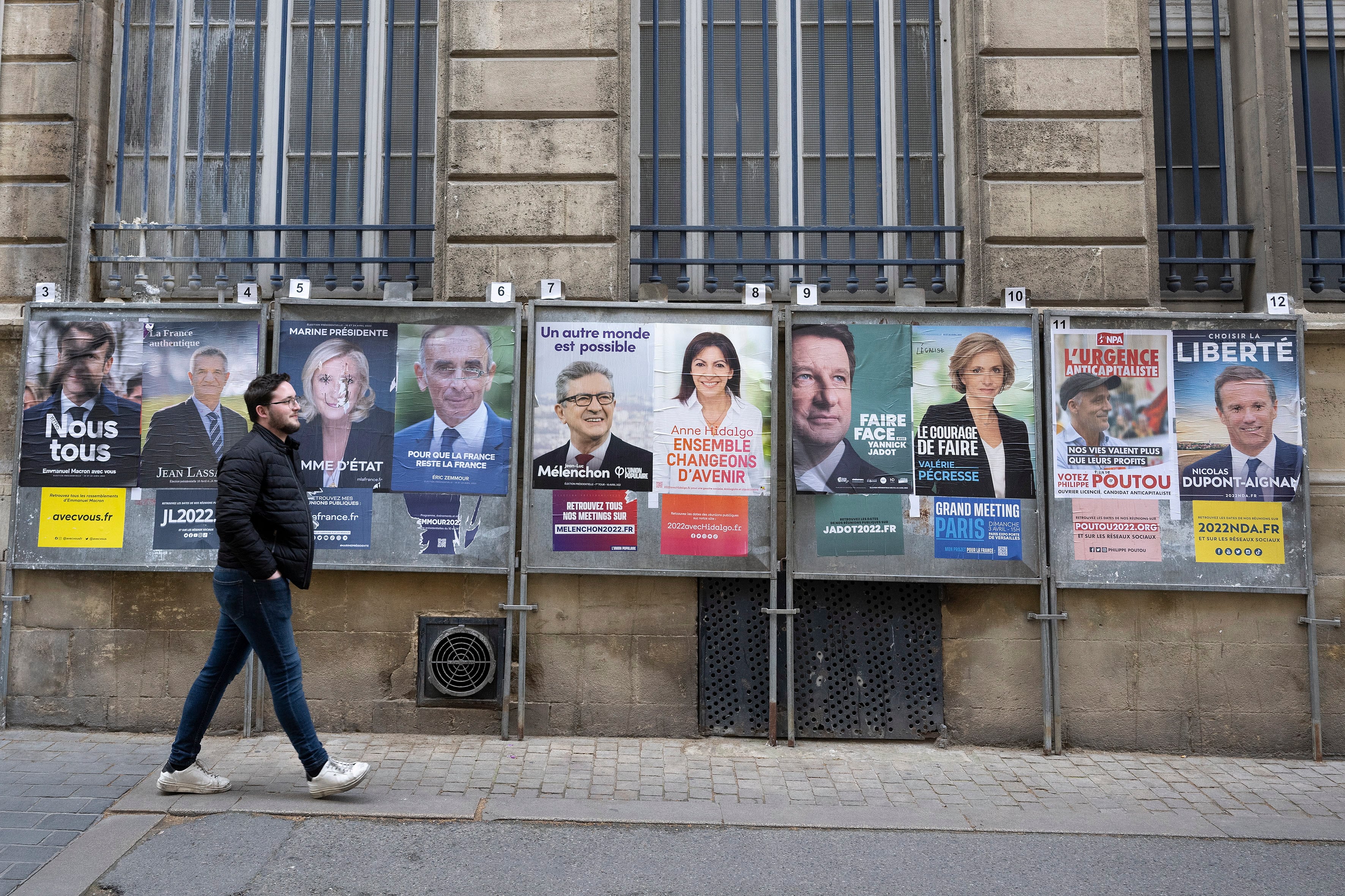 Un hombre pasea frente a los carteles electorales en Francia