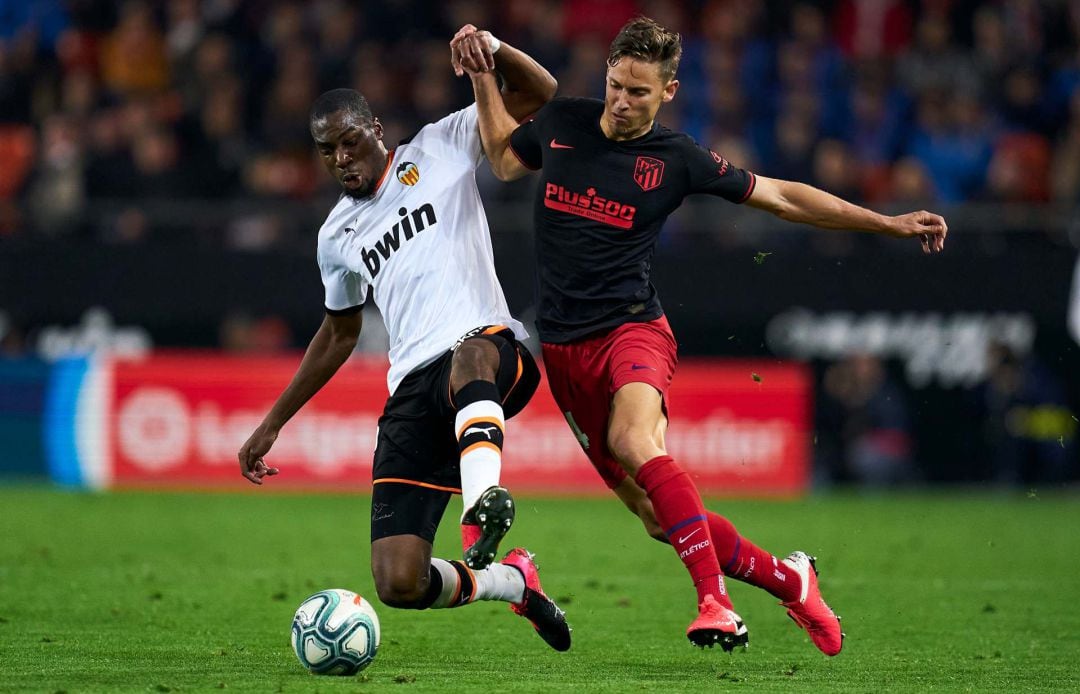 Geoffrey Kondogbia, con Marcos Llorente, en un partido entre el Valencia y el Atlético de Madrid.