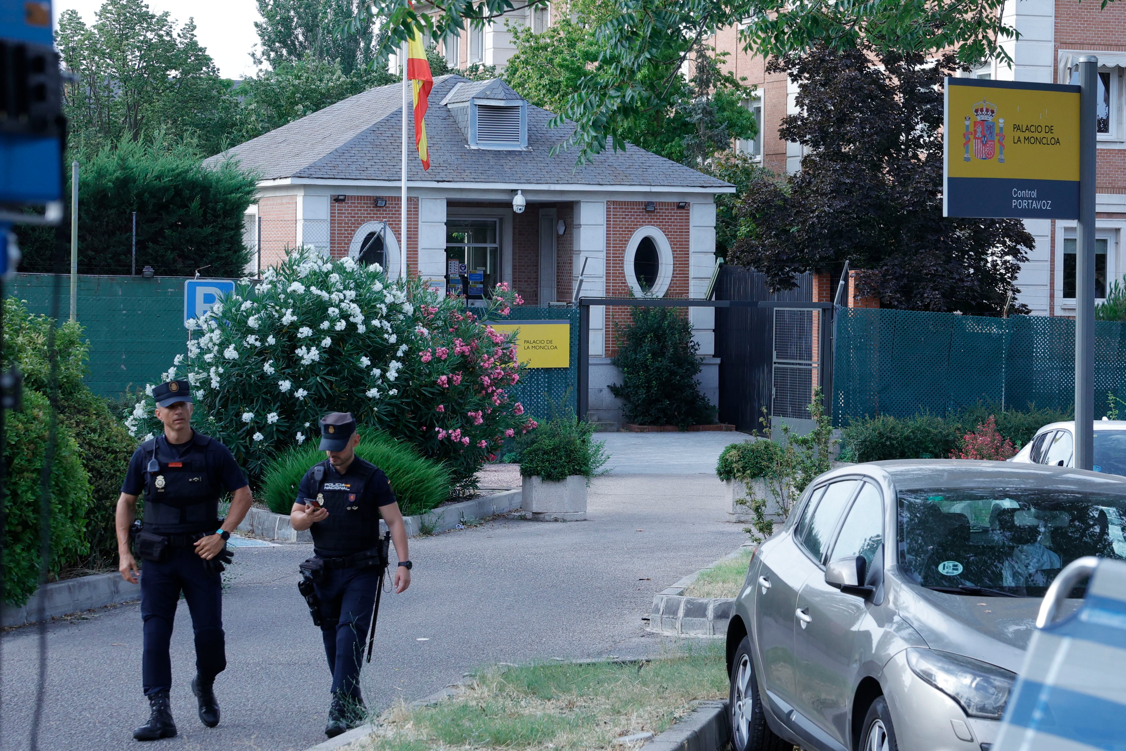 Dos agentes de la Policía Nacional caminan en el exterior del Palacio de la Moncloa