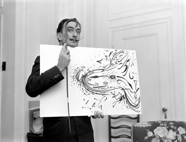 Salvador Dali enseña una de sus obras.