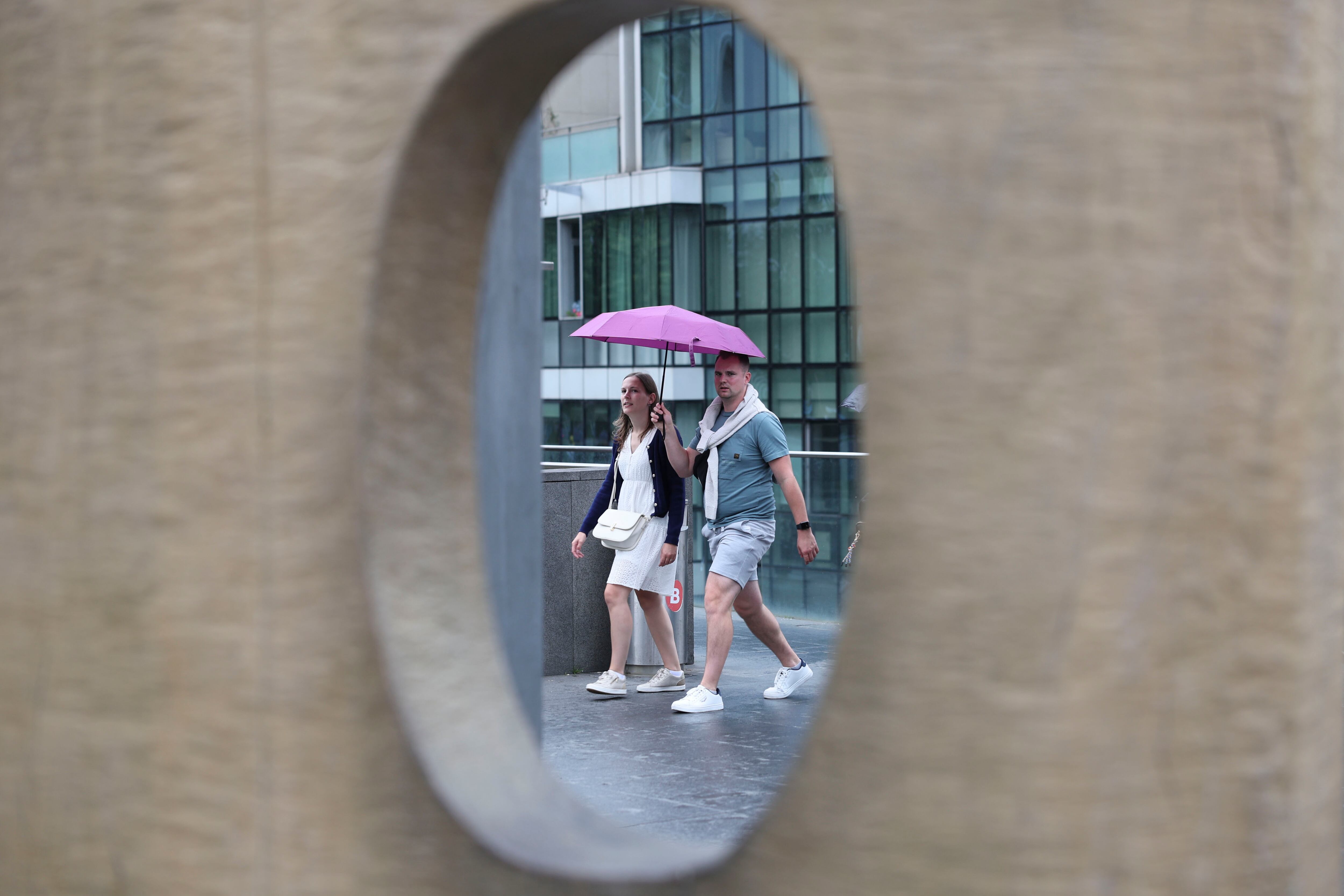 GRAFCAV1959. BILBAO, 27/08/2025.- Una pareja se protege con paraguas EFE/Luis Tejido