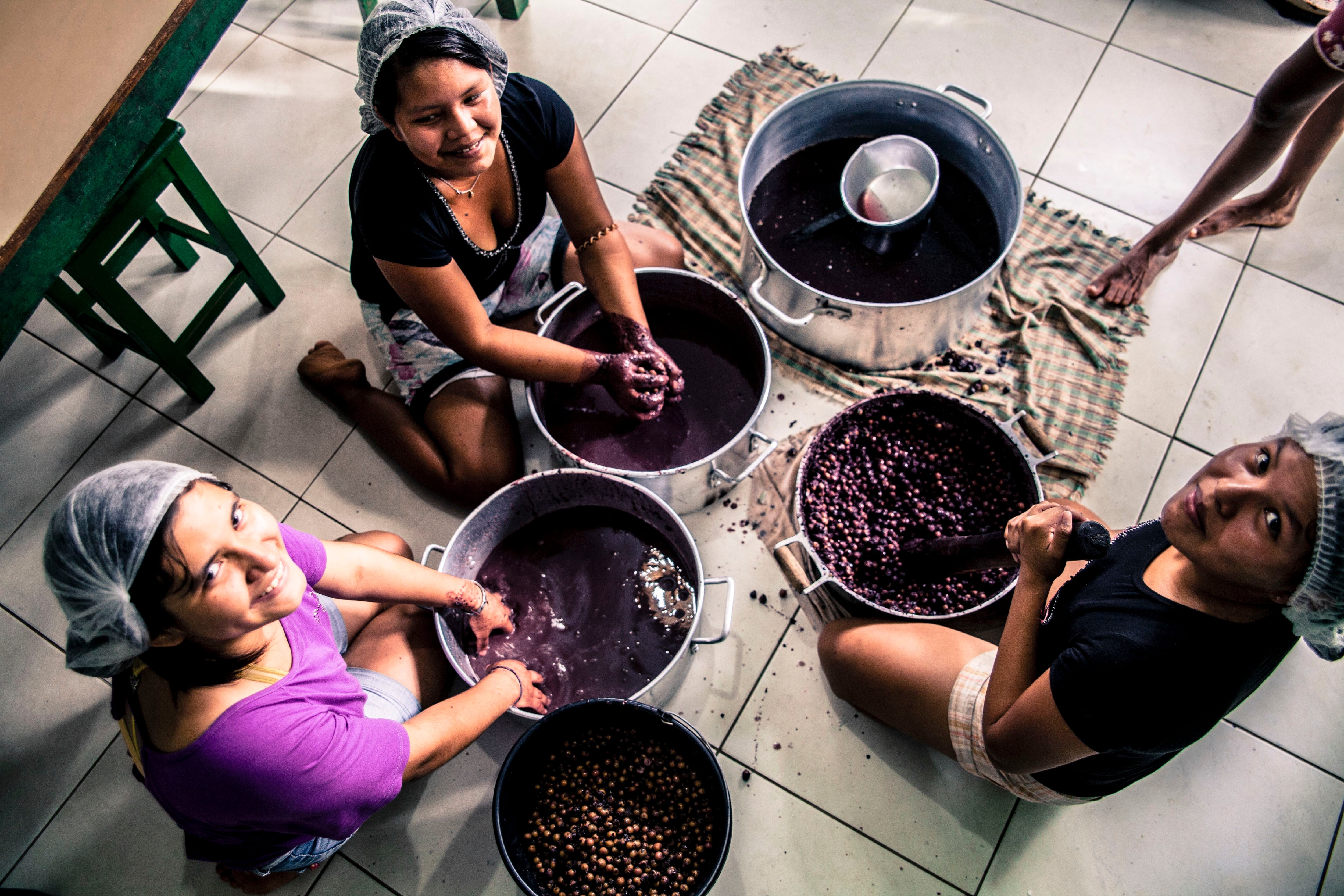 Un grupo de mujeres preparan zumo de açai en la región donde crecen abundantemente, en el norte de Brasil.