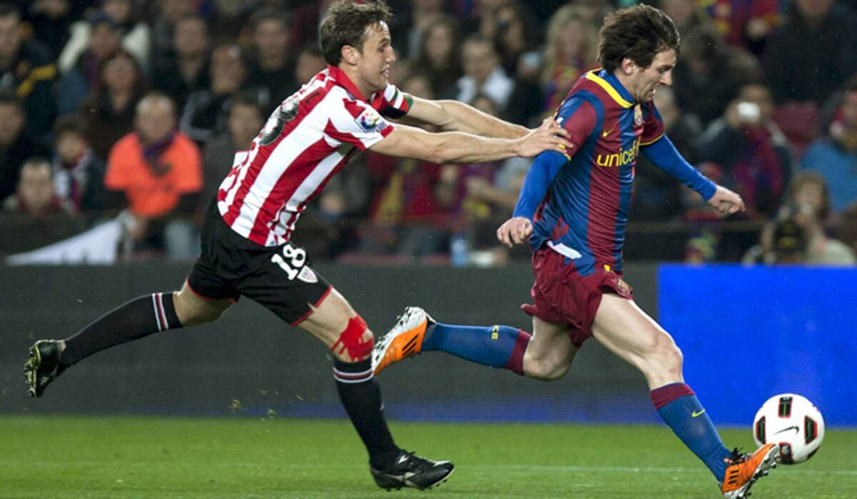 El delantero argentino del FC Barcelona Lionel Messi (d) y el centrocampista del Athletic Club Carlos Gurpegi durante el partido correspondiente a la vigésimo cuarta jornada de Liga de Primera División que ambos equipos disputan esta noche en el Camp Nou