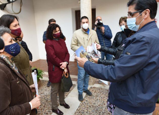 Jose Manuel Caballero, presidente de la Diputación de Ciudad Real observa el calendario de Afanion junto a otras autoridades