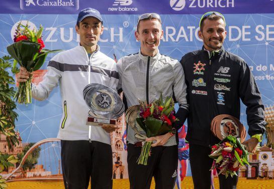 El atleta catalán Carles Castillejo (c), que ha sido segundo en la 32 edición del maratón de Sevilla y se ha proclamado así campeón de España de la modalidad, posa en el podio acompañado de Jesús España, sexto en la prueba y subcampeón de España y José Ca