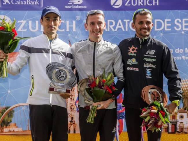 El atleta catalán Carles Castillejo (c), que ha sido segundo en la 32 edición del maratón de Sevilla y se ha proclamado así campeón de España de la modalidad, posa en el podio acompañado de Jesús España, sexto en la prueba y subcampeón de España y José Ca