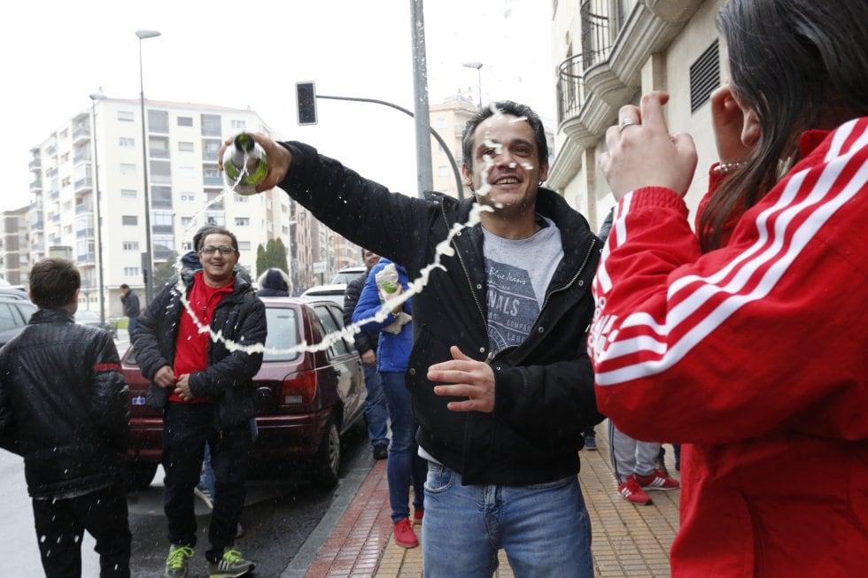 Un hombre celebra con una botella de champán que le ha tocado el Gordo de la Lotería con el nº 26590, frente al gimnasio Seiza 2 donde se repartió el número, en Salamanca