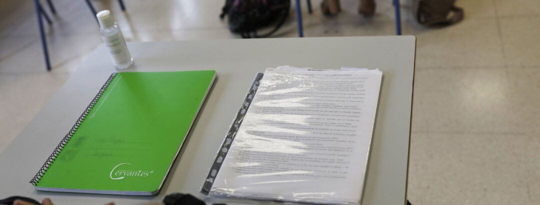 Cuadernos en una mesa de un aula, foto de archivo