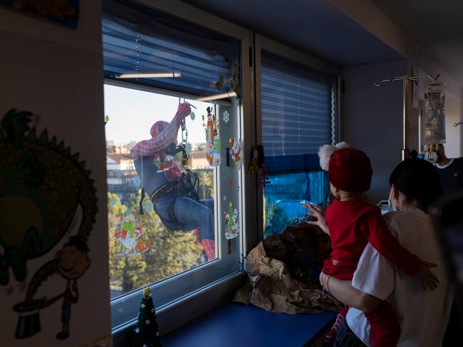 GRAFAND7551. MÁLAGA, 18/12/2023.- Spiderman se ha descolgado por la fachada del Hospital Materno de Málaga, desde el tejado con la ayuda de un bombero, para saludar a los niños ingresados en las plantas de enfermedades infecciosas, Oncología, Lactantes y Cirugía a través de las ventanas. EFE/Carlos Díaz