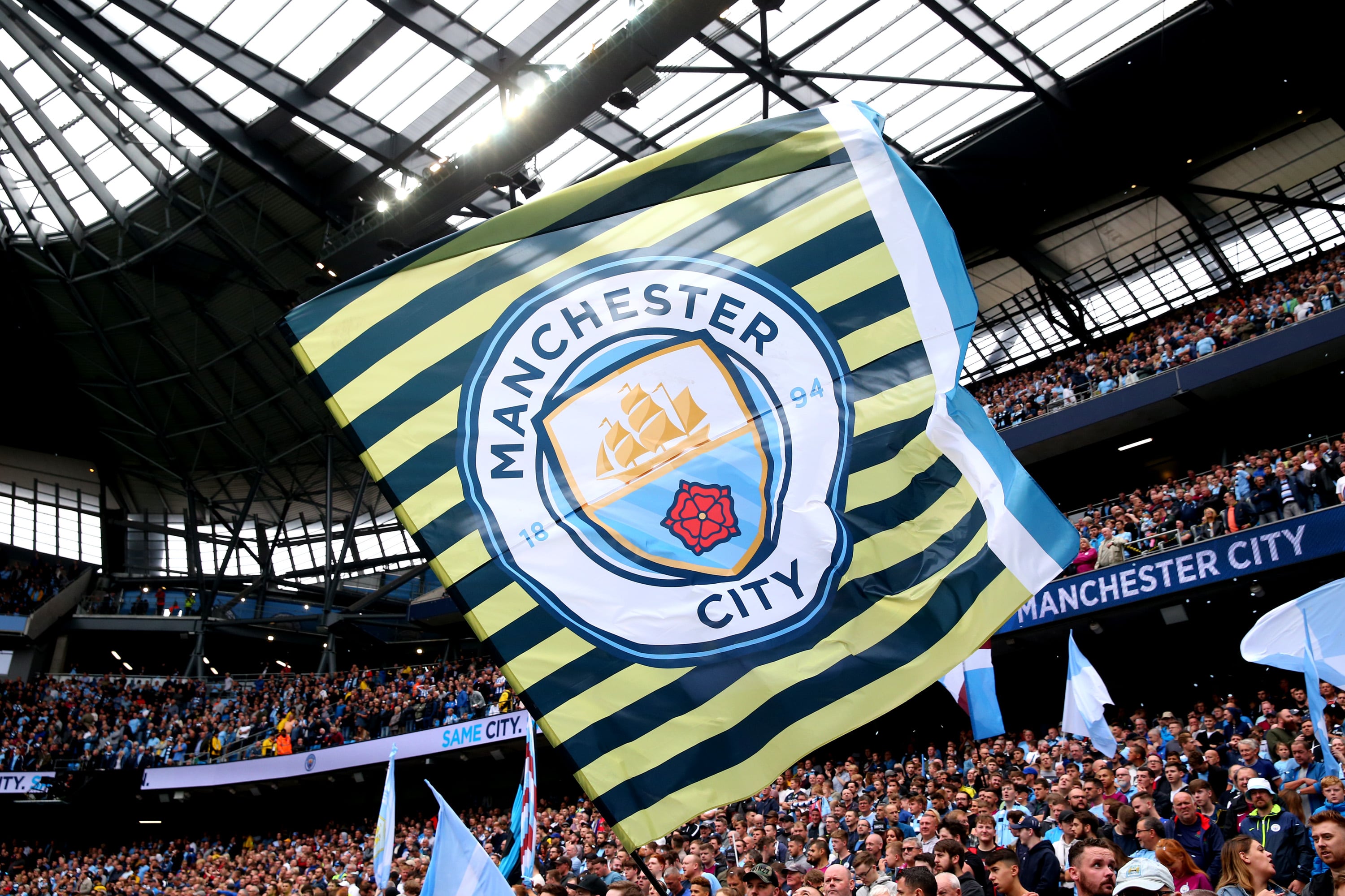 La afición del Manchester City ondea una bandera de su equipo durante un partido.