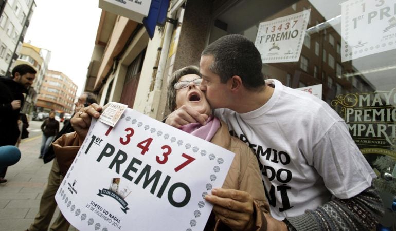 El dueño de la administración de A Coruña donde tocó el primer premio del Sorteo Extraordinario de Lotería de Navidad se abraza con su tía momentos después de conocerse el premio