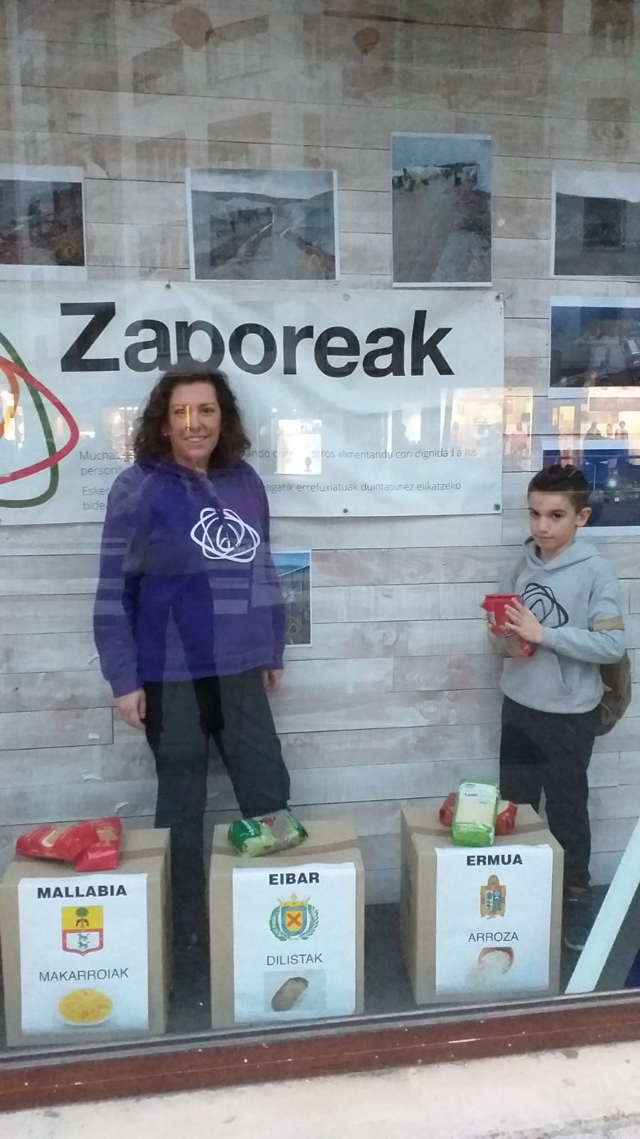 Mireia Alonso y Xabier Larrañaga en el escaparate del local de recogida de Zaporeak en la calle Julián Etxebarria