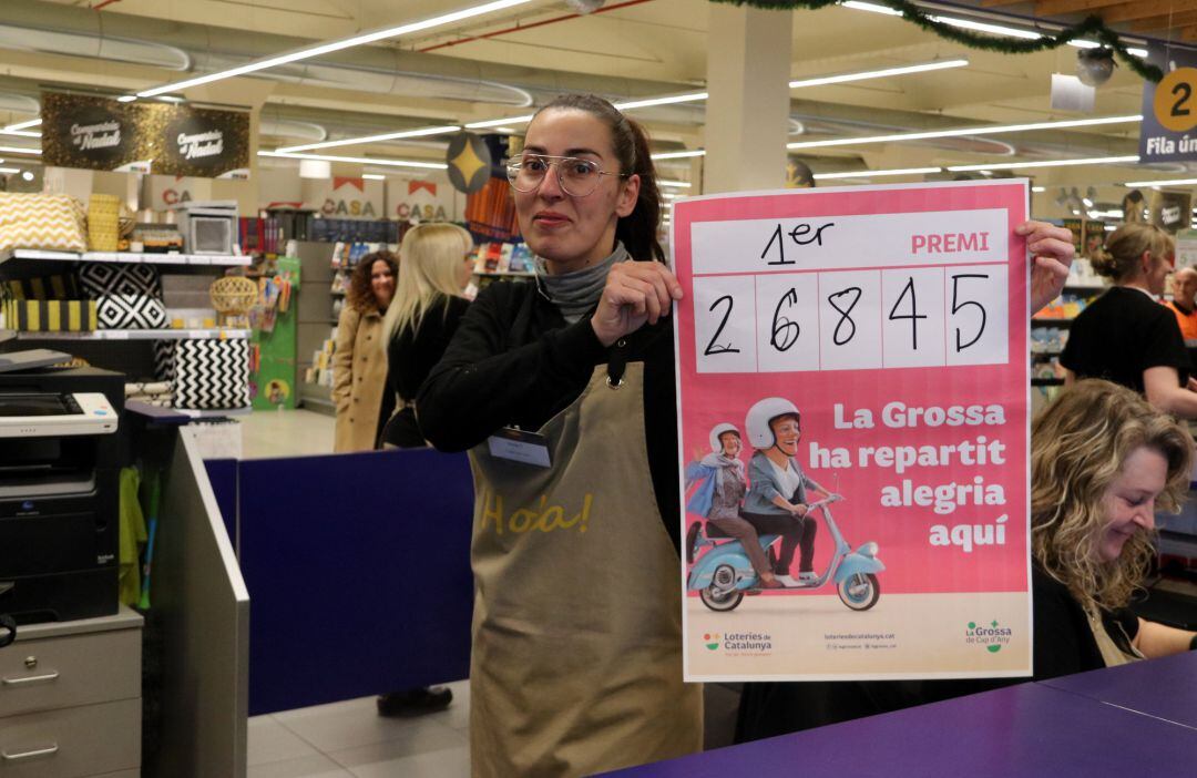Una treballadora amb el cartell on s&#039;anuncia que han venut el primer premi de la Grossa de Cap d&#039;Any