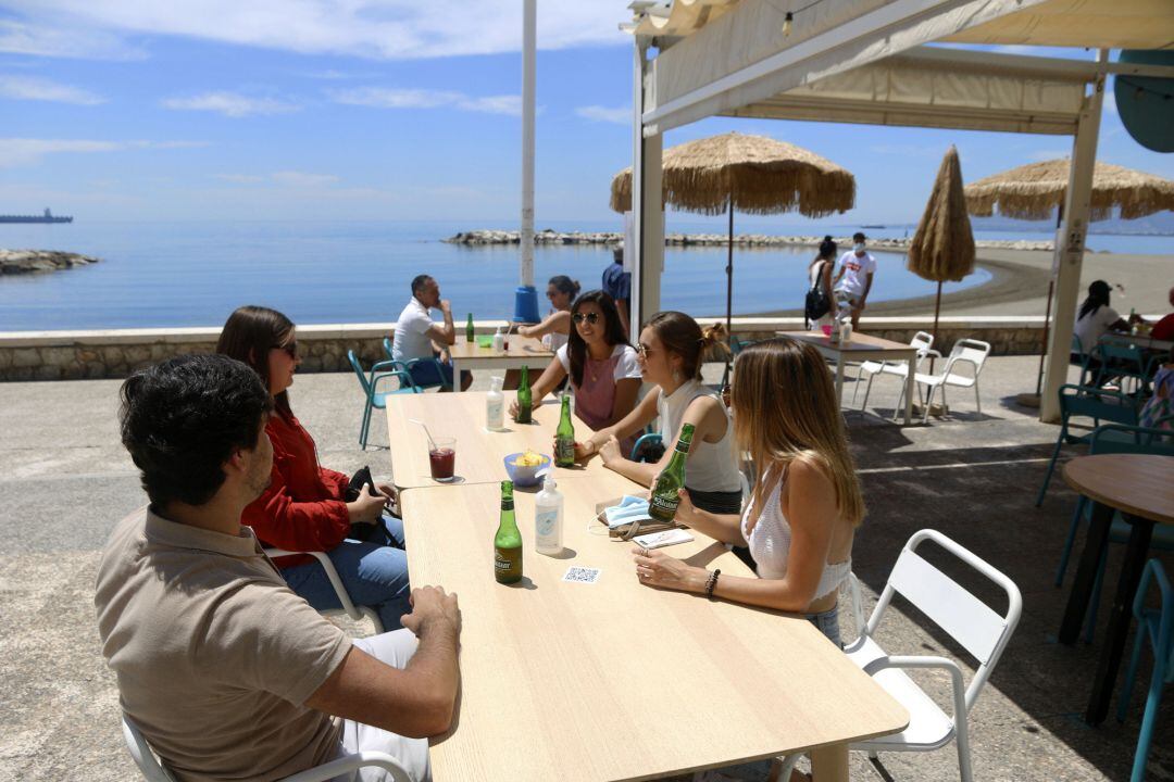 Varias personas disfrutan de la terraza de un bar en el paseo marítimo de Pedregalejo durante la Fase 1 en Málaga