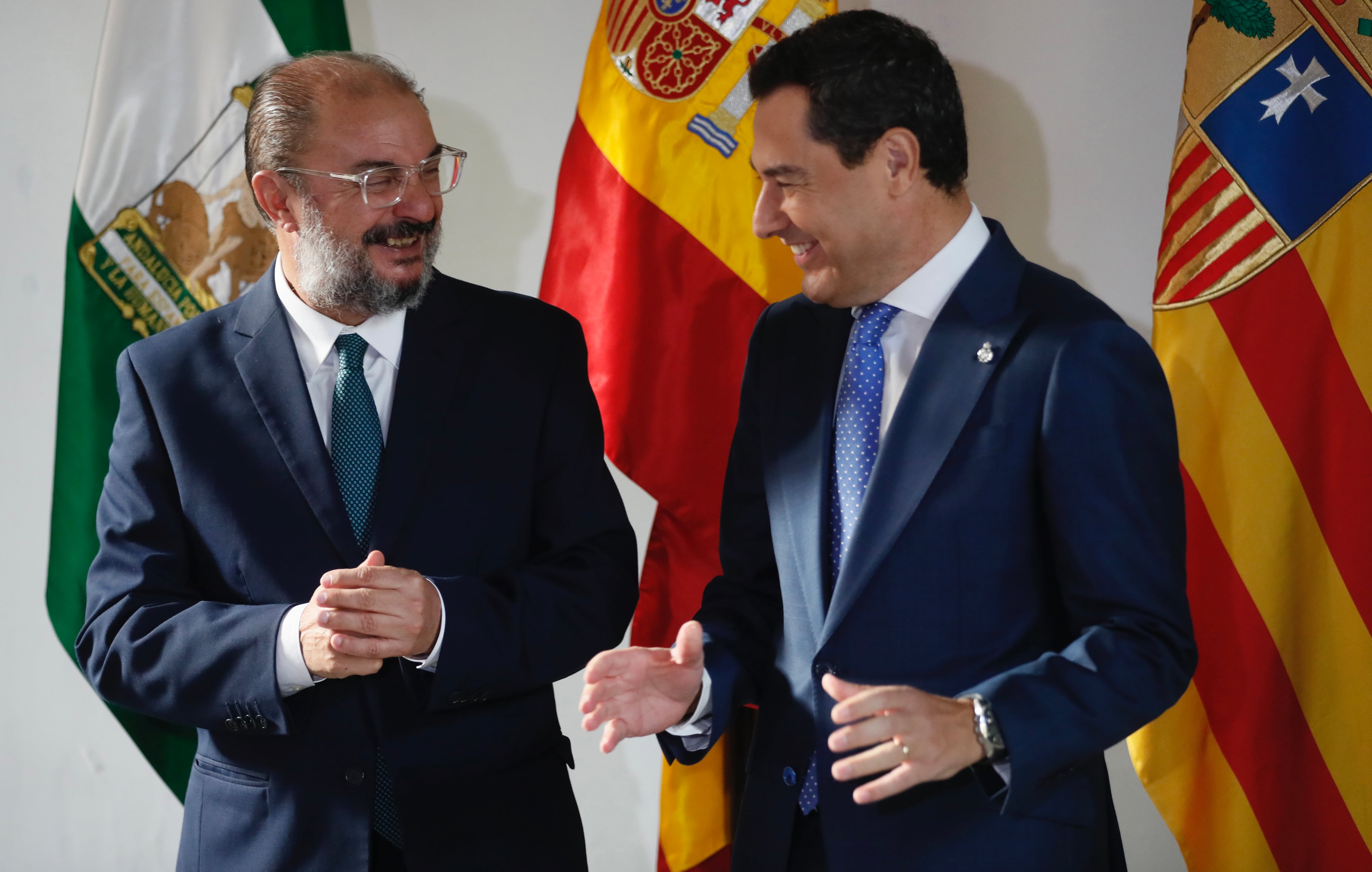 Los presidentes de la Junta de Andalucía, Juanma Moreno (d), y el del Gobierno de Aragón, Javier Lambán, conversan a su llegada al Palacio de San Telmo este jueves en Sevilla, donde han mantenido una reunión. EFE/José Manuel Vidal