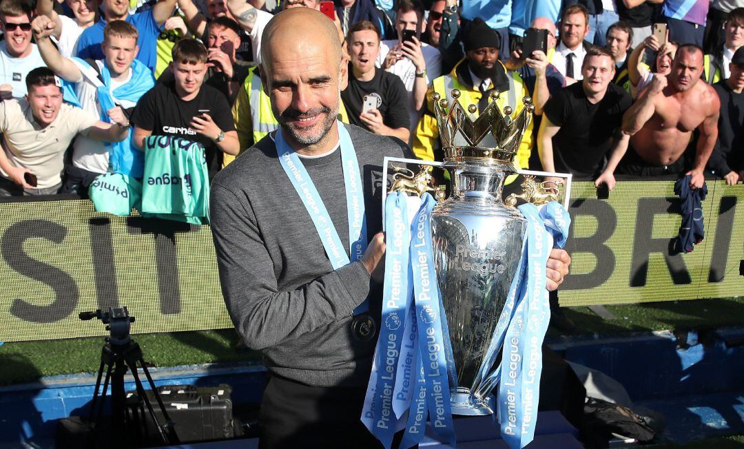 Guardiola sujeta el trofeo de la premier después de ganar el triplete este año.