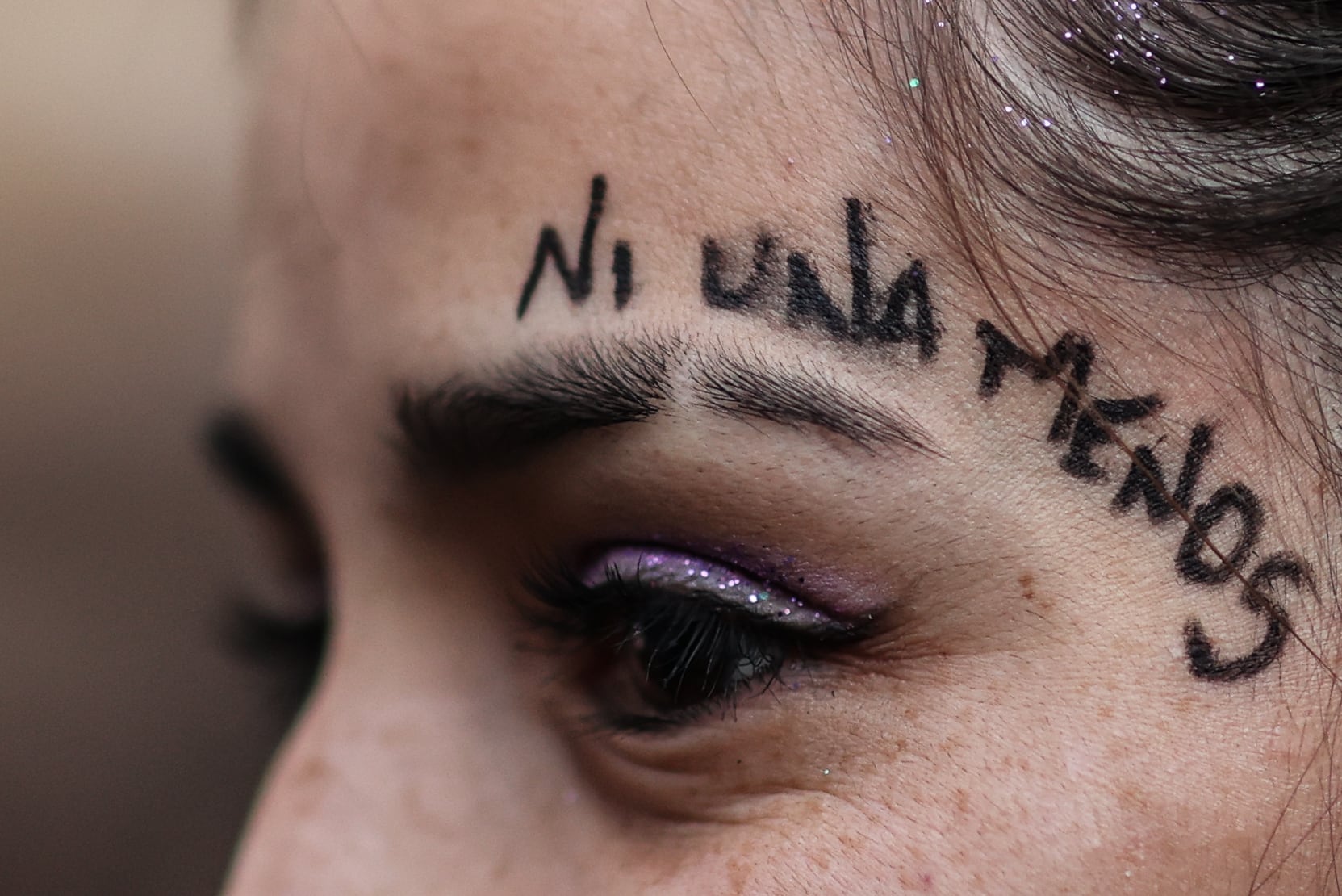 Una mujer participa con miles de mujeres en una marcha bajo la consigna &quot;ni una menos&quot; en conmemoración de los siete años de la creación de este colectivo feminista