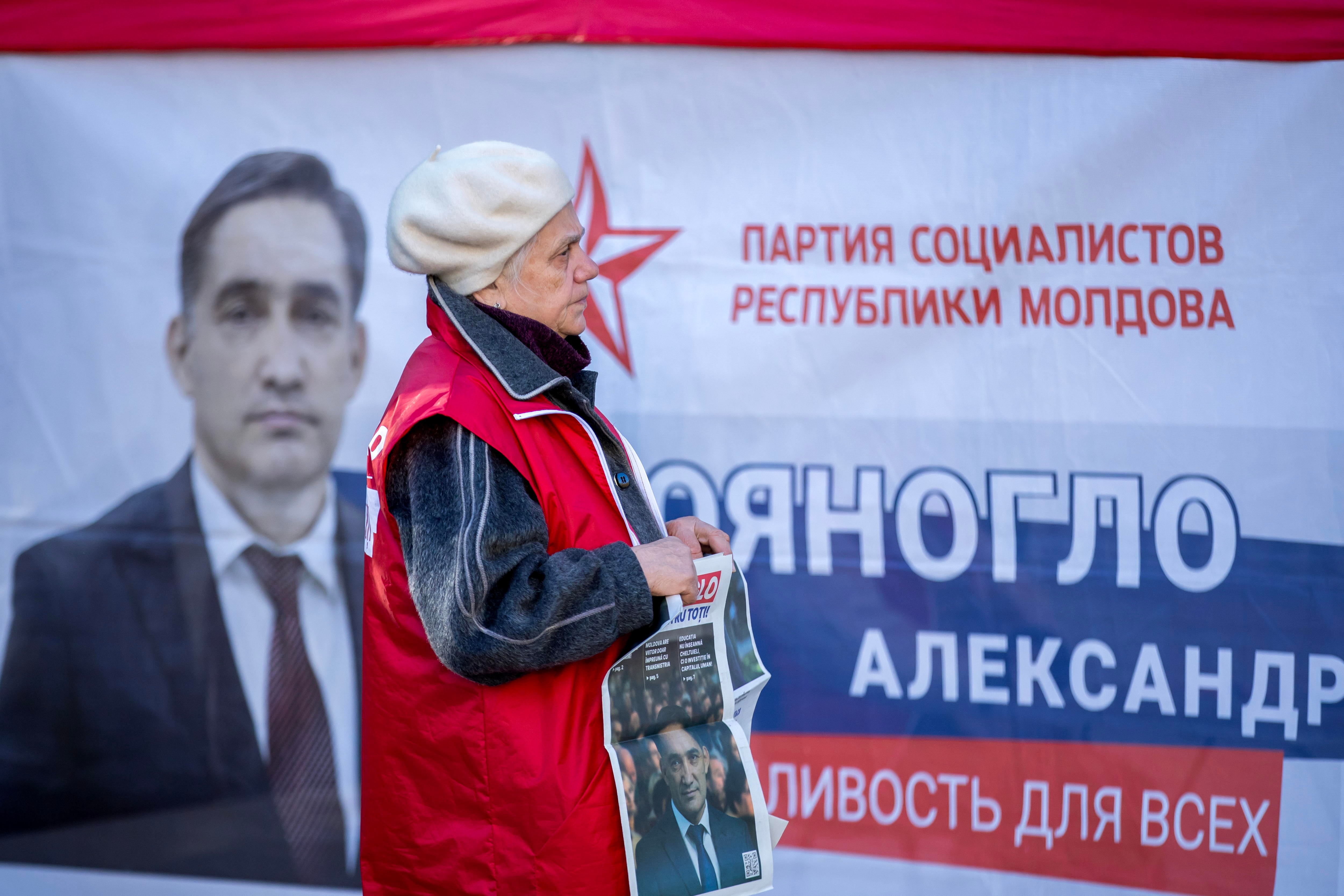 Una mujer junto a un cartel de campaña del candidato prorruso en Chisinau, Moldavia