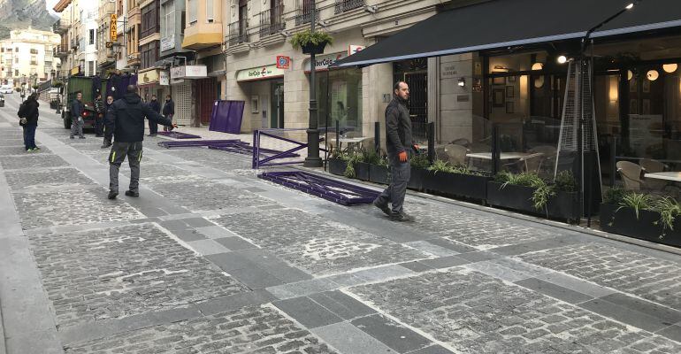 Los operarios comienzan a instalar las vallas de Semana Santa en la Carrera.