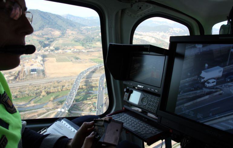 Un agente controla el tráfico desde un helicóptero del Servei Català de Trànsit