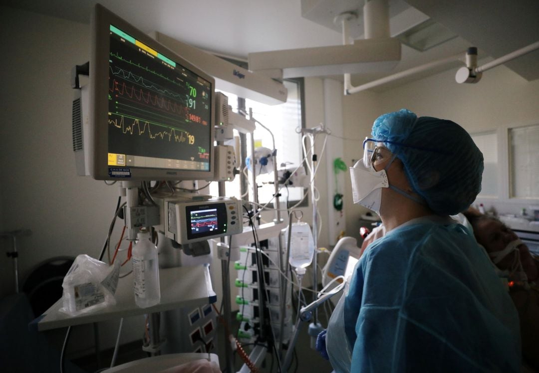 Un sanitario observa un monitor en una UCI. Imagen de archivo