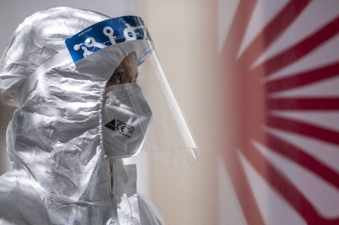 Una sanitaria se equipa con un EPI.