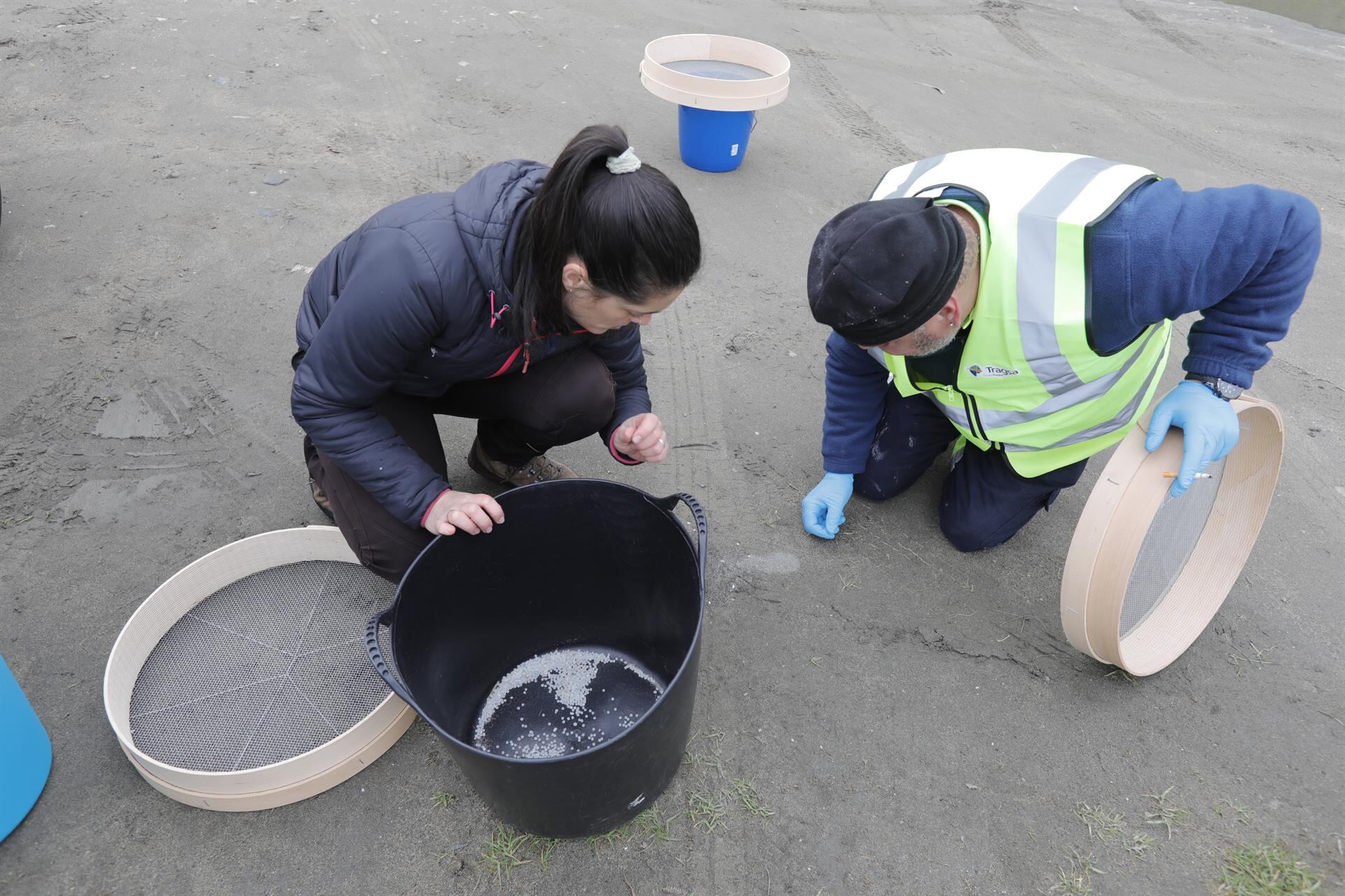 Operarios de TRAGSA recogen pellets de plástico, en la playa de Otur.