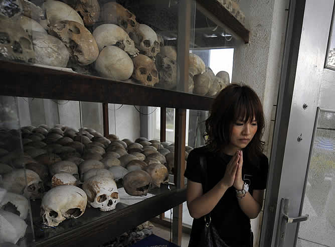 Una joven de Tokio coloca sus manos en señal de respeto por las víctimas que murieron en uno de los campos de extermino de la capital de Camboya, Phnom Penh