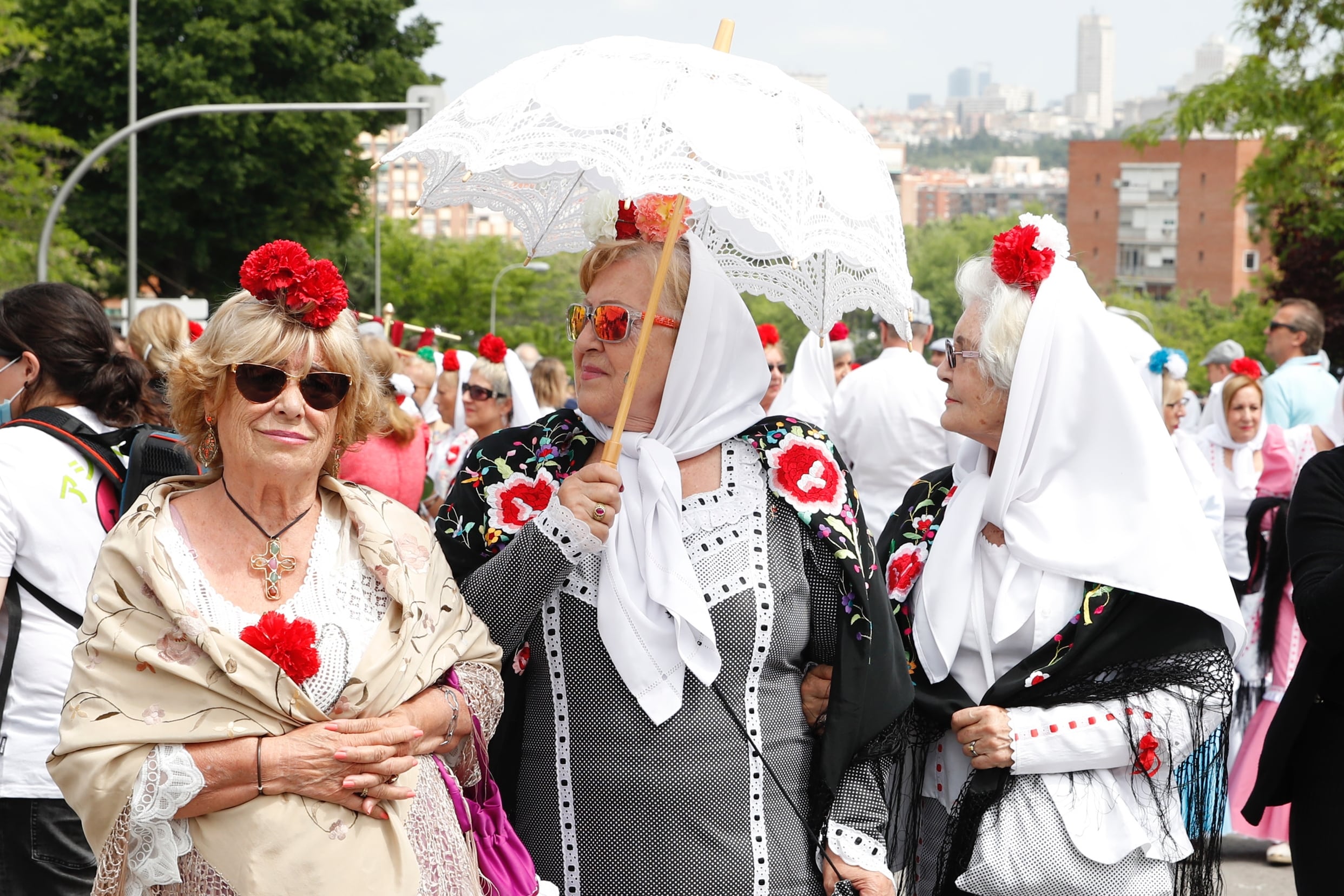 Varias chulapas recorren la Pradera de San Isidro para celebrar la festividad del patrón de Madrid, este domingo, en la capital española.