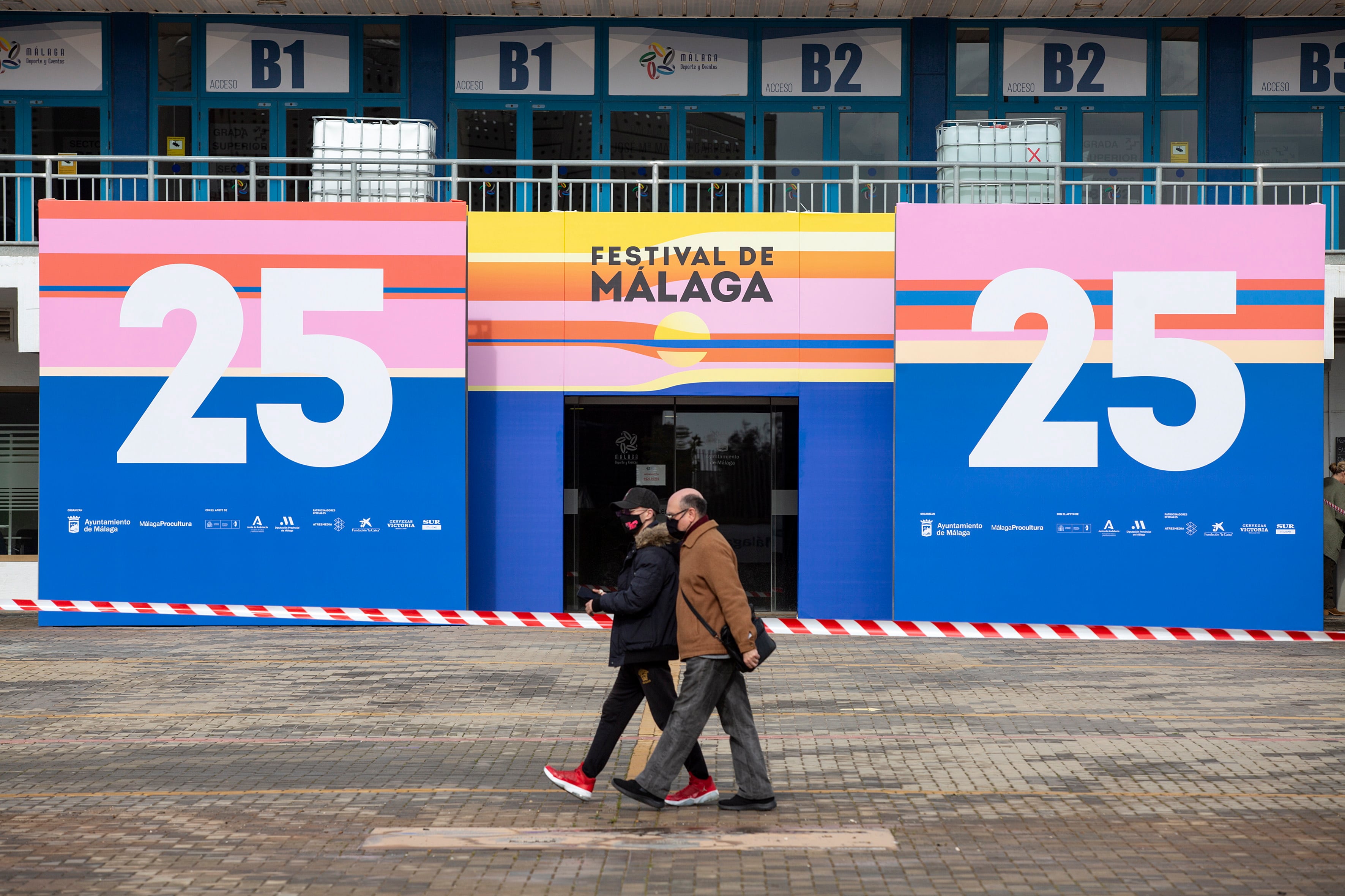 Dos personas caminan junto al Palacio de los Deportes José María Martín Carpena donde se celebrará, este viernes, la gala inaugural del Festival de Cine en Español de Málaga EFE/Daniel Pérez