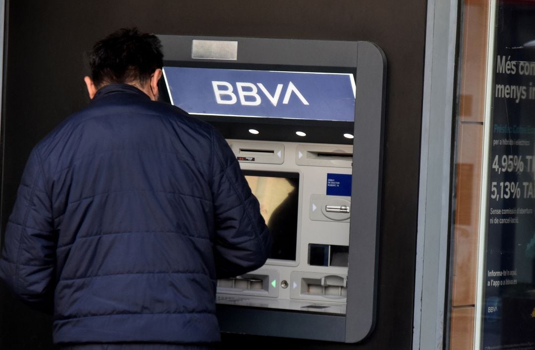 Una persona saca dinero de un cajero de BBVA.