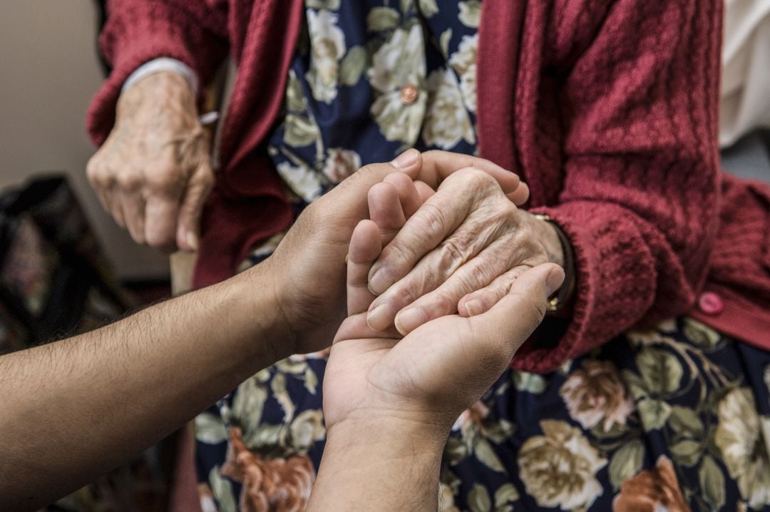 Imagen recurso de una persona ayudando a una anciana.