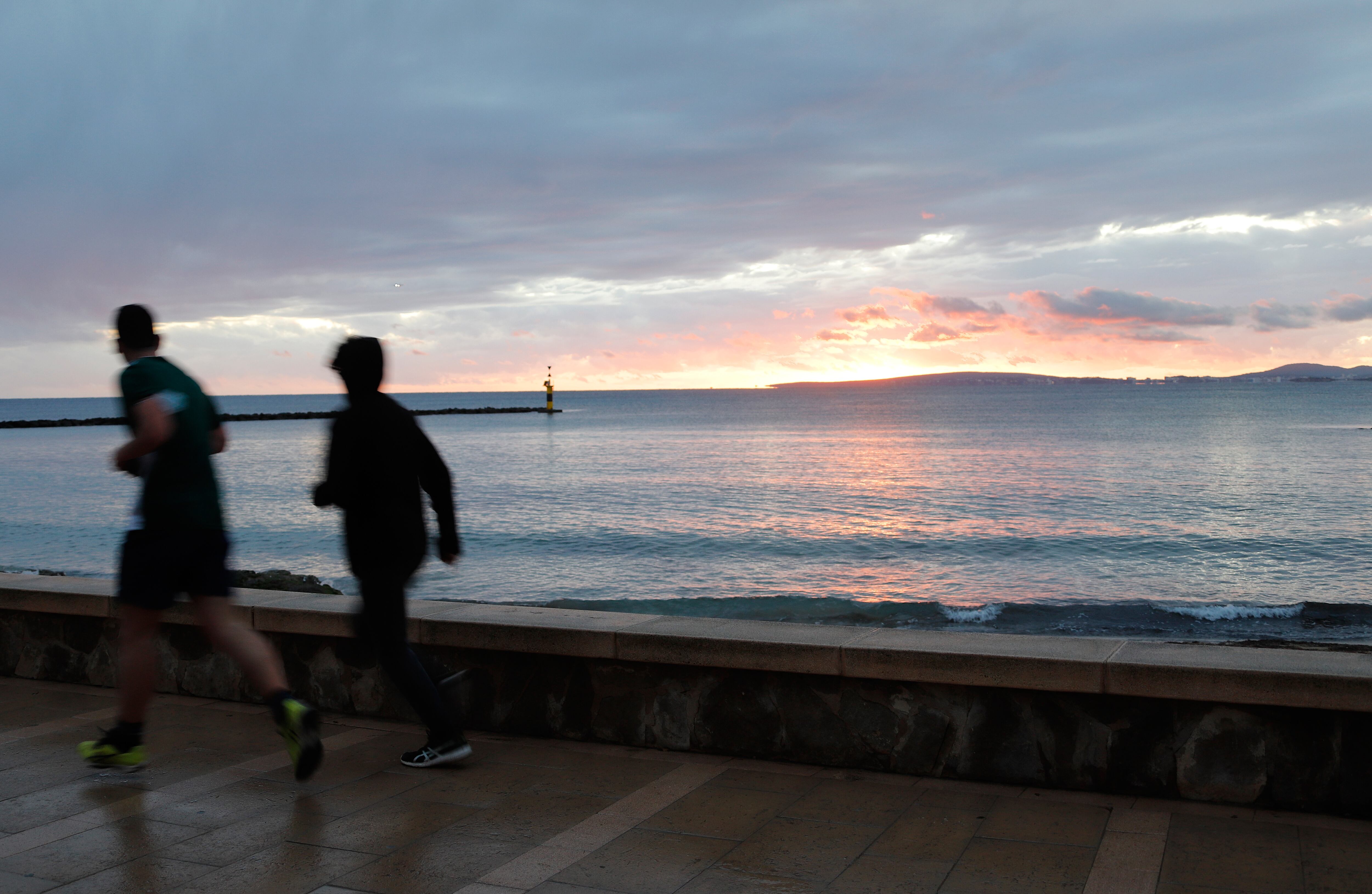 25 December 2020, Spain, Palma: People walking on the promenade at the beach of Palma on a rainy day. Cold and rain characterize the weather forecast in Mallorca for the next few days. Photo: Clara Margais/dpa (Photo by Clara Margais/picture alliance via Getty Images)