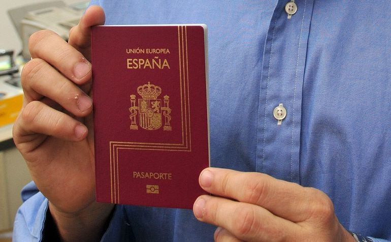 Hombre sujeta el pasaporte español tras conseguir la nacionalidad