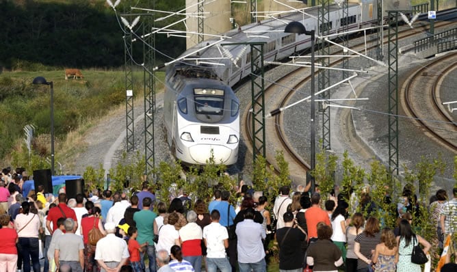 Familiares de víctimas observan el paso del tren de las 20:40 en la curva de Angrois, justo un año después del accidente.