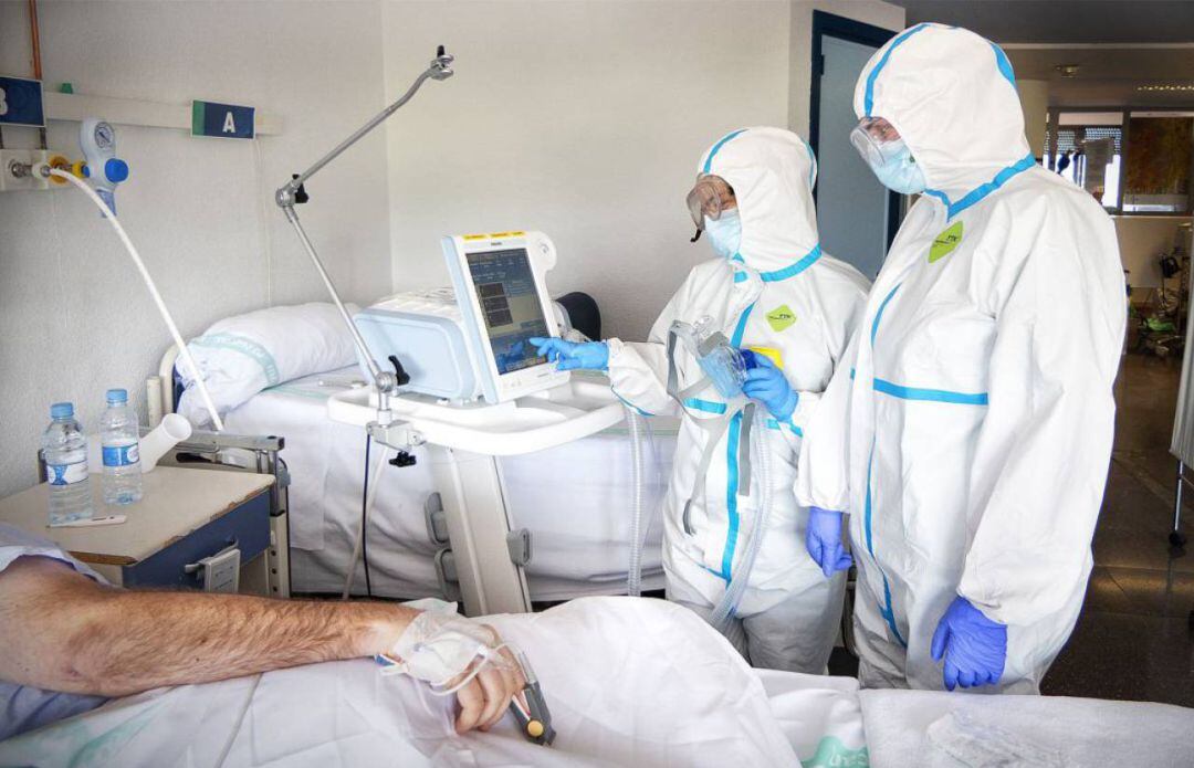 Dos doctores atendiendo a un enfermo Covid. 