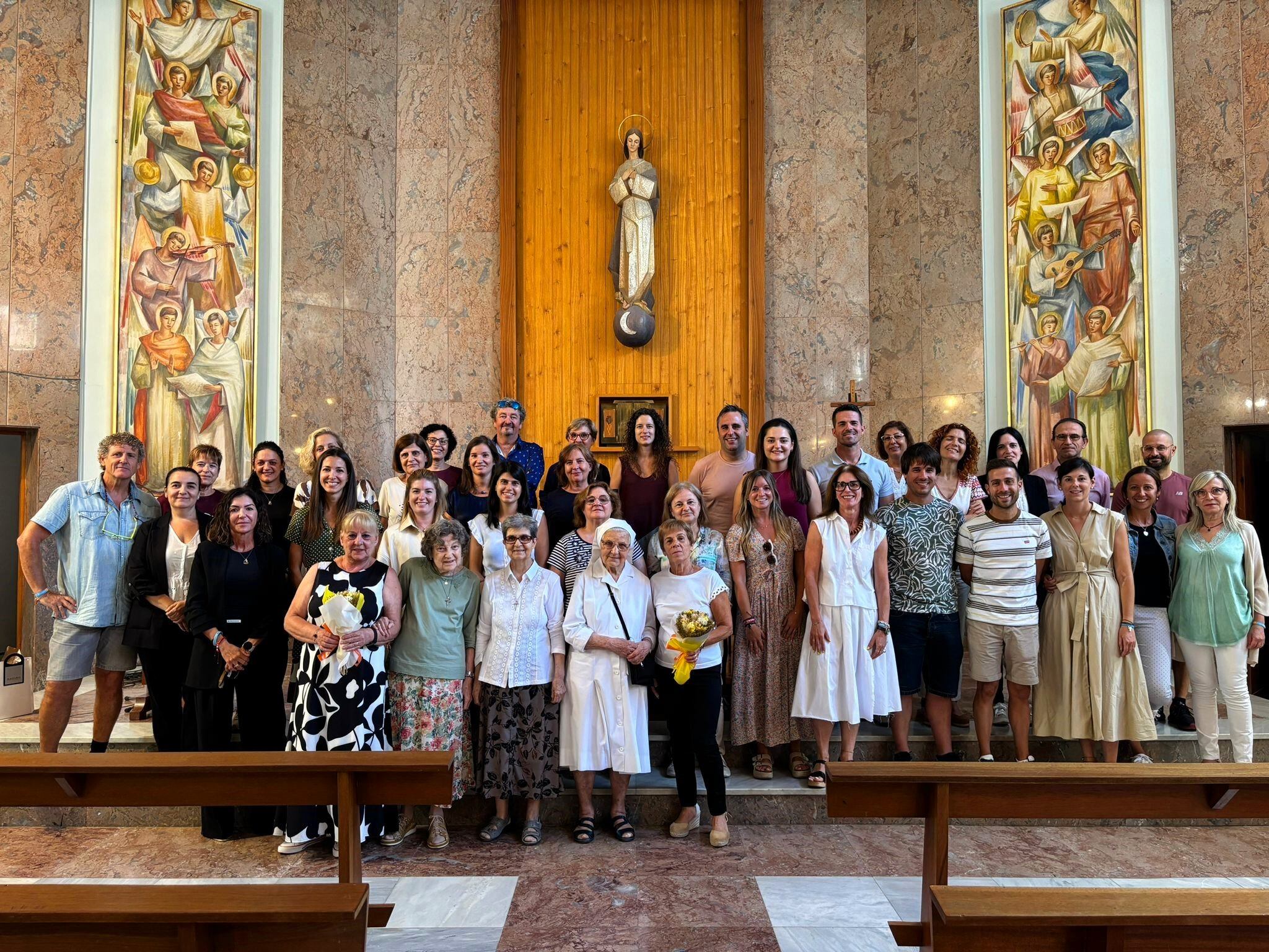 Las tres religiosas, junto a profesores y padres en la capilla en el comienzo de curso del colegio