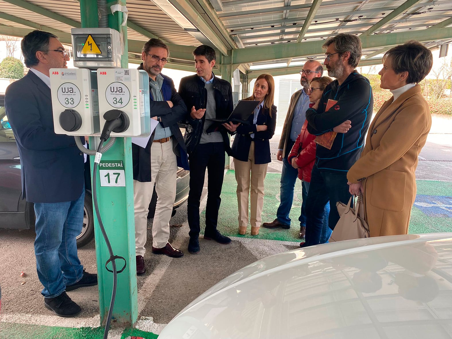 El rector de la UJA, Juan Gómez (segundo por la izqda), visita uno de los puntos de recarga de los vehículos eléctricos instalados.