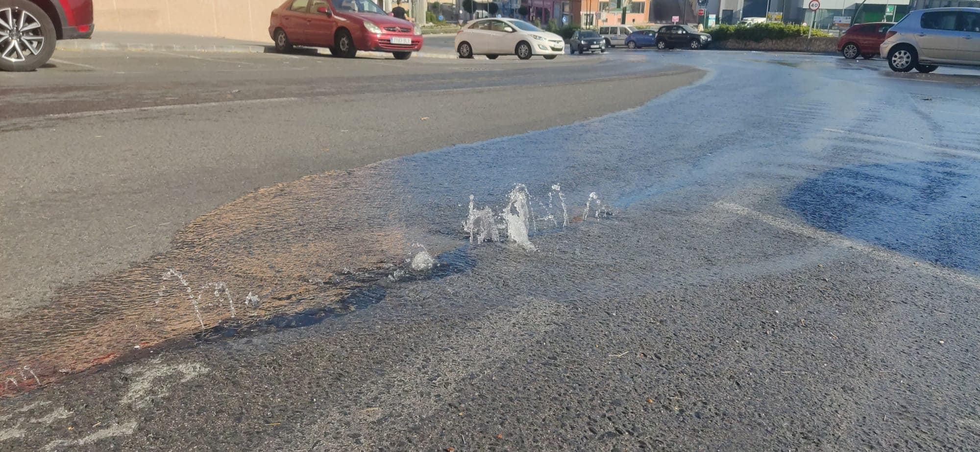 El agua emergiendo en medio de la carretera de subida al polideportivo