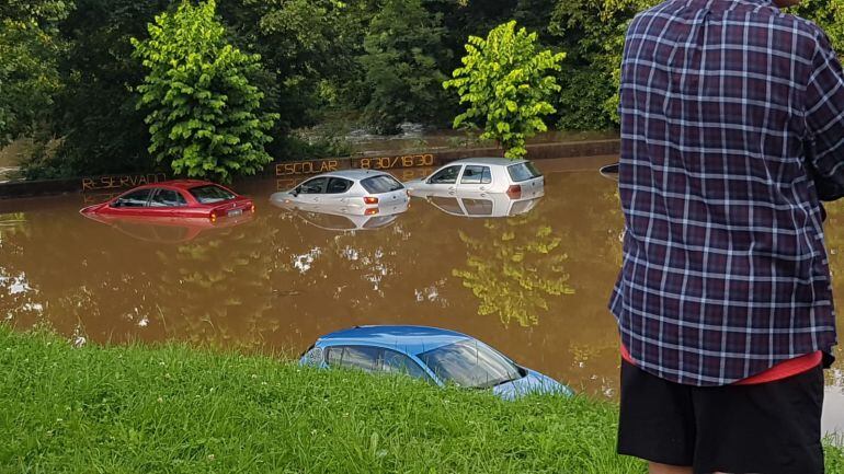 Imagen de los coches cubiertos de agua en el aparcamiento de Rolaceña.