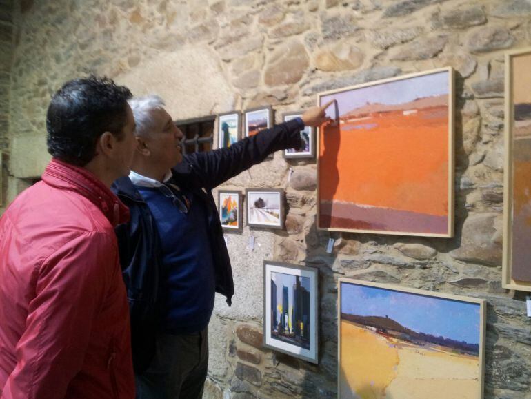 El pintor Pedro Pacios comentando uno de sus cuadros junto al concejal Roberto Mendo durante la presentación.