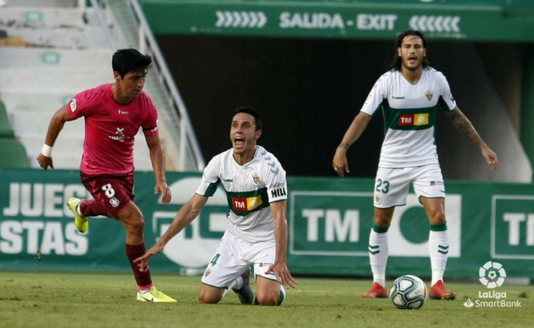 Los jugadores del Elche Ramón Folch y Juan Cruz reclaman al árbitro en un lance del Elche-Tenerife