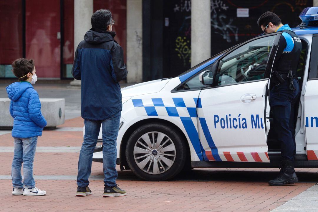Un policía municipal pide la documentación a un padre y a su hijo para comprobar la distancia de su domicilio en la ciudad de Valladolid
