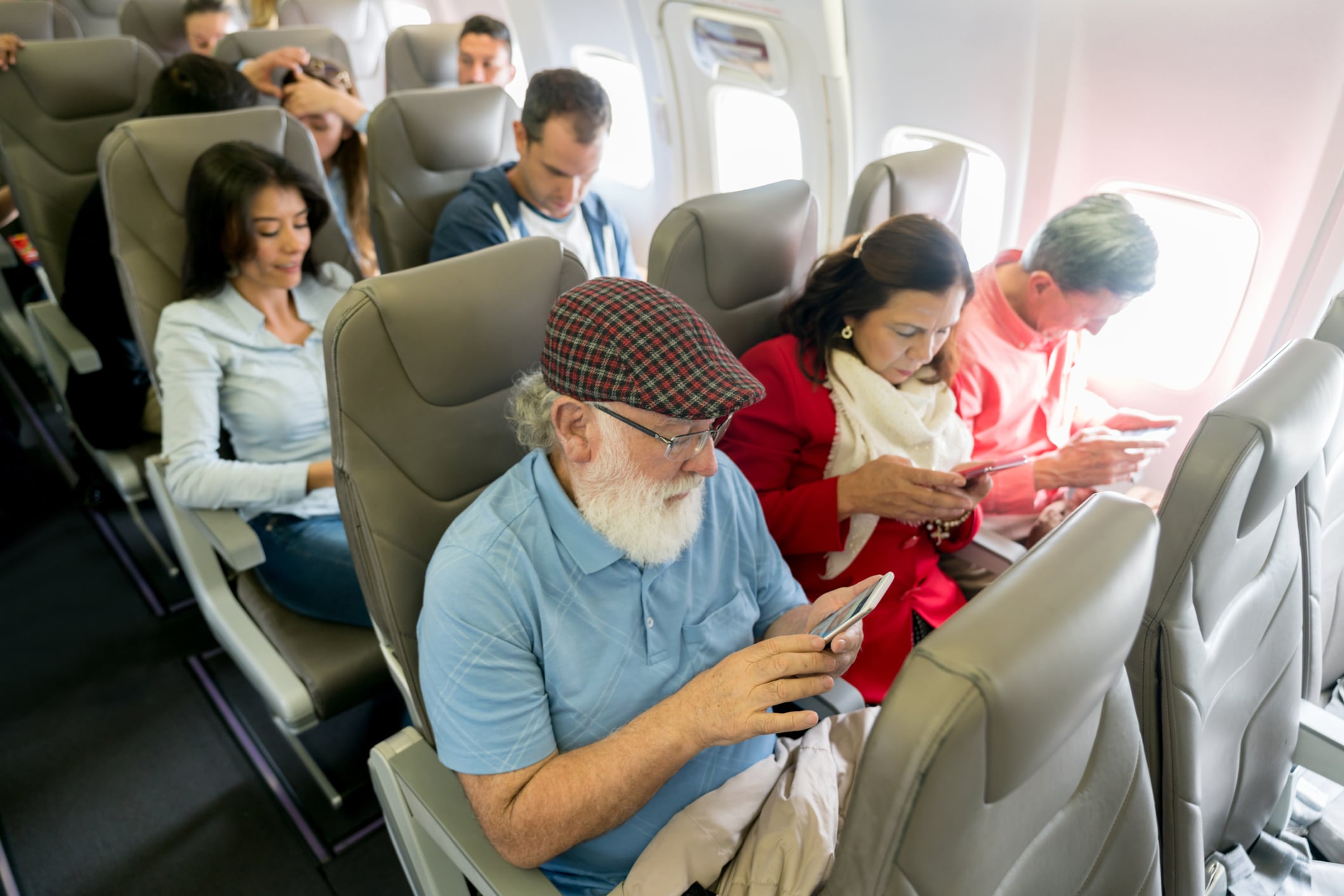 Pasajeros de un avión utilizan el móvil.