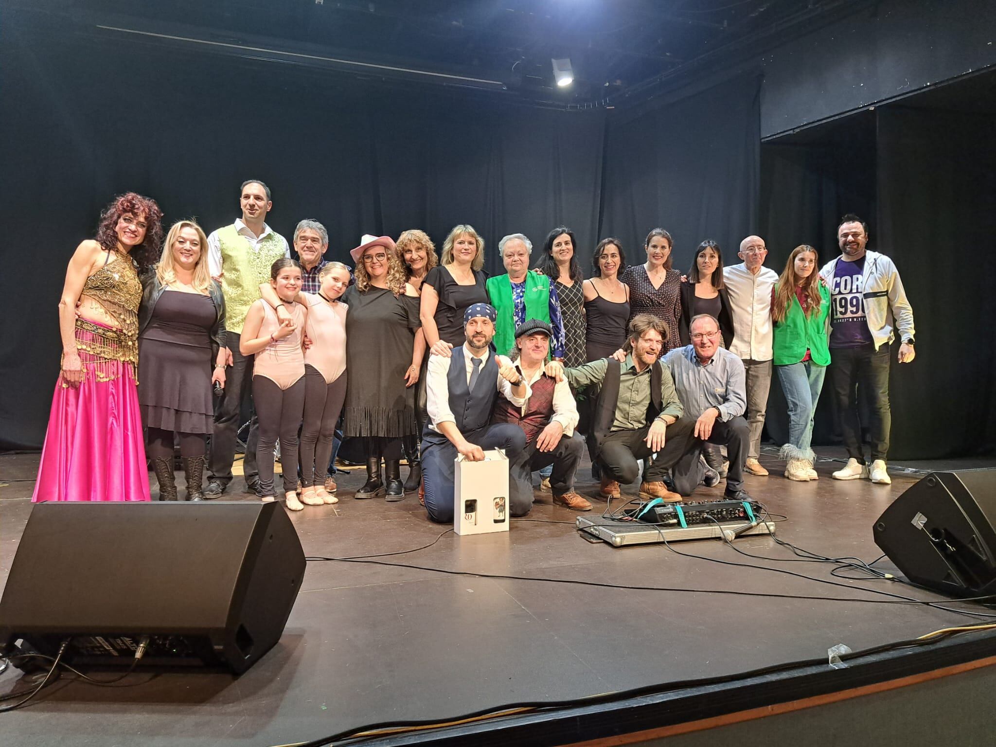 Foto final del concierto, con los músicos y bailarinas, representantes de la AECC y Jacinto, conserje de la Casa de Cultura, que recibió también un reconocimiento por su entregada colaboración en este y otros eventos similares